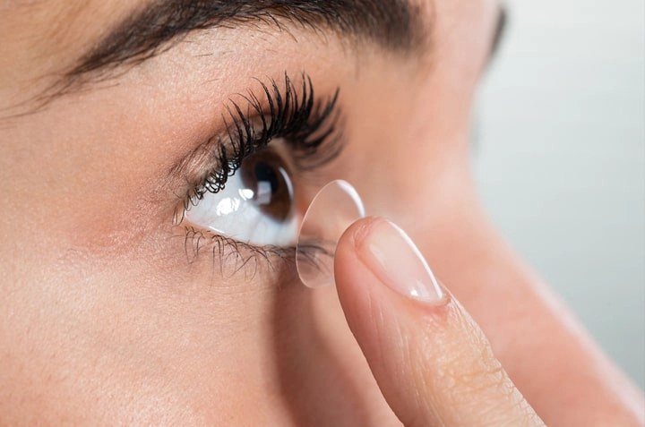 A contact lens being placed on the eye